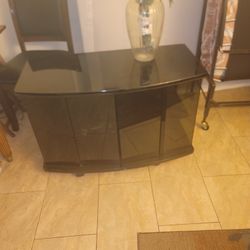 Black glass TV stand with storage space.