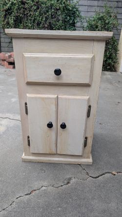 Wooden sand colored end table with a drawer and cabinet underneath