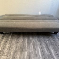 Two gray futons and two cream occasional chairs