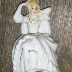PORCELAIN REGENCY LADY SITTING ON A CHAIR GOLD ACCENTS MADE IN JAPAN.  THE FIGURINE IS IN VERY GOOD CONDITION AND MEASURES APPROXIMATELY 3 INCHES TALL