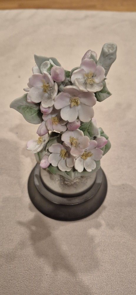 This is a porcelain figurine of apple blossoms made by Royal Worcester. The piece was modeled by Dorothy Doughty for her 