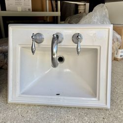 White Kohler bathroom sink with faucet.  