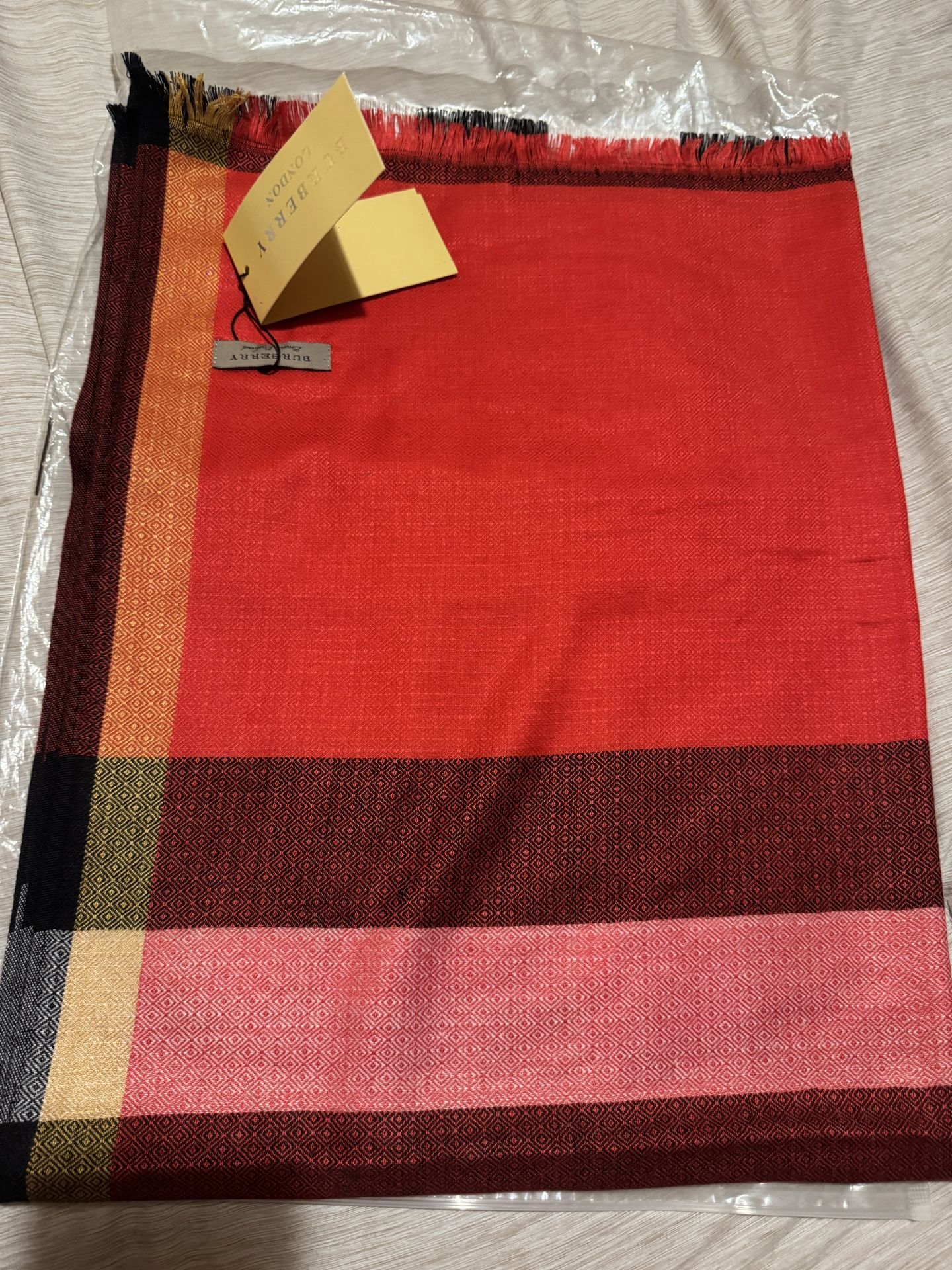 Burberry Check Cashmere Scarf in a multi-tonal red, black, and pink colorway.