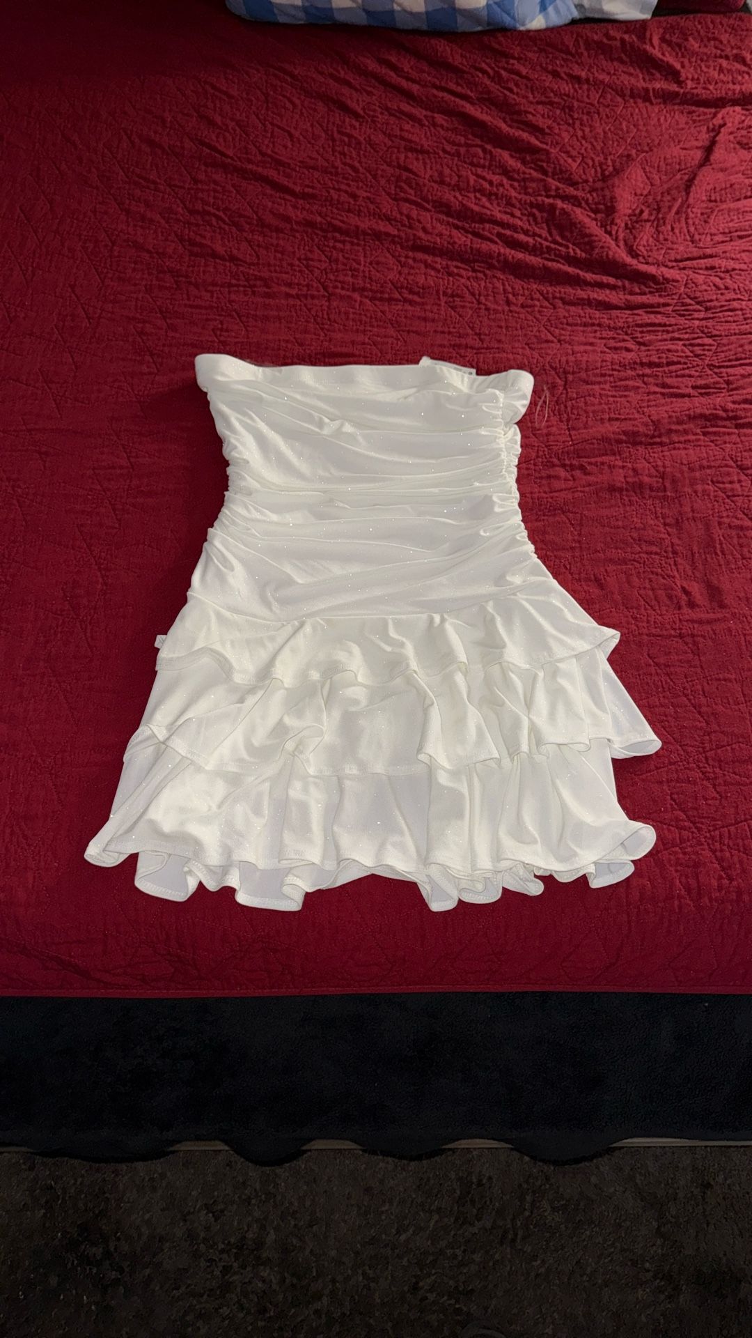 white strapless mini dress with a ruched bodice and a tiered ruffle skirt.