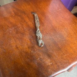 This is a vintage silver-plated cheese knife with a grape vine design on the handle. It is often sold as a single item or as part of a set of cheese k