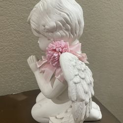 Statue of angel with folded hands praying, close up
