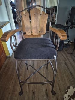 Metal and Wood Bar Stool with Cushion has a small tear on q of them