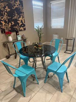 Round Glass Top Dining Table with 4 Teal Metal Chairs