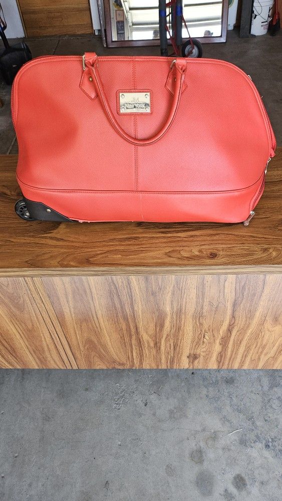 J. M. NEW YORK RED DUFFLR BAG WITH WHEELS AND PULL HANDLE