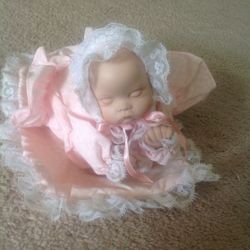 Baby doll music box rolls and plays music when you windup
