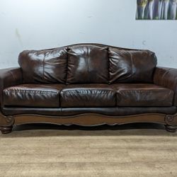 Ashley Brown Bonded Leather Couch with Wood Trim