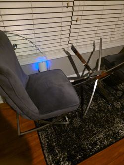 2 grey velvet tufted chairs and glass table