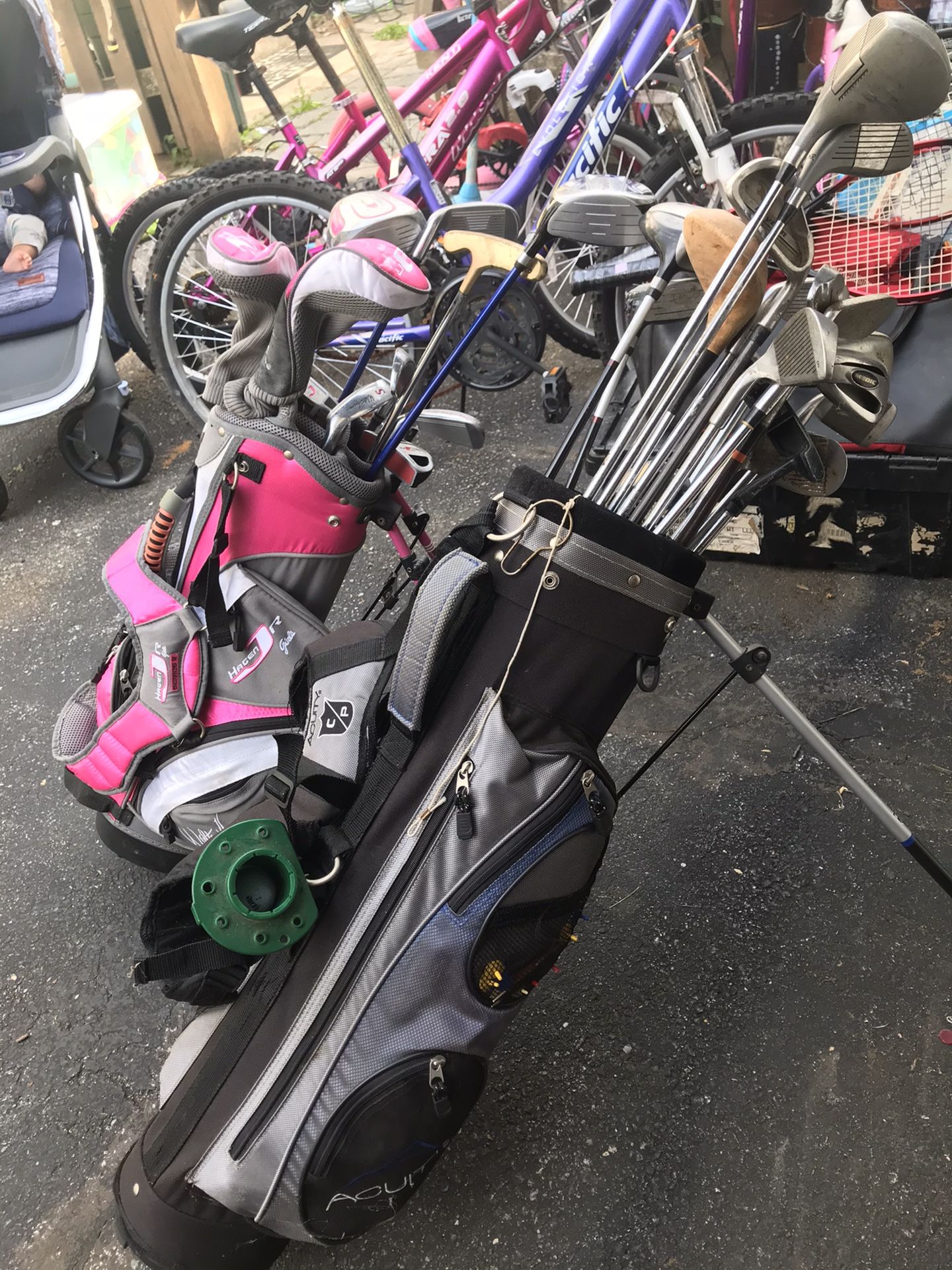 Men and womens set of professional golf clubs with golf bags and balls and tees.