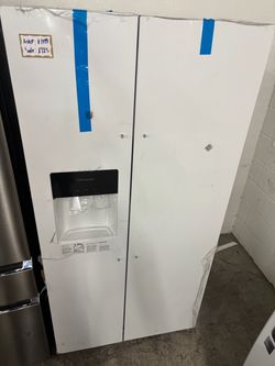White Frigidaire side-by-side refrigerator has an external water and ice dispenser. This unit is finished in white and includes protective plastic fil
