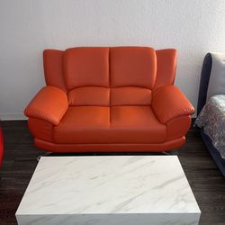 Red 2 Seat Couch with White Coffee Table