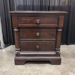 Traditional Dark Wood Three-Drawer Nightstand with Turned Columns