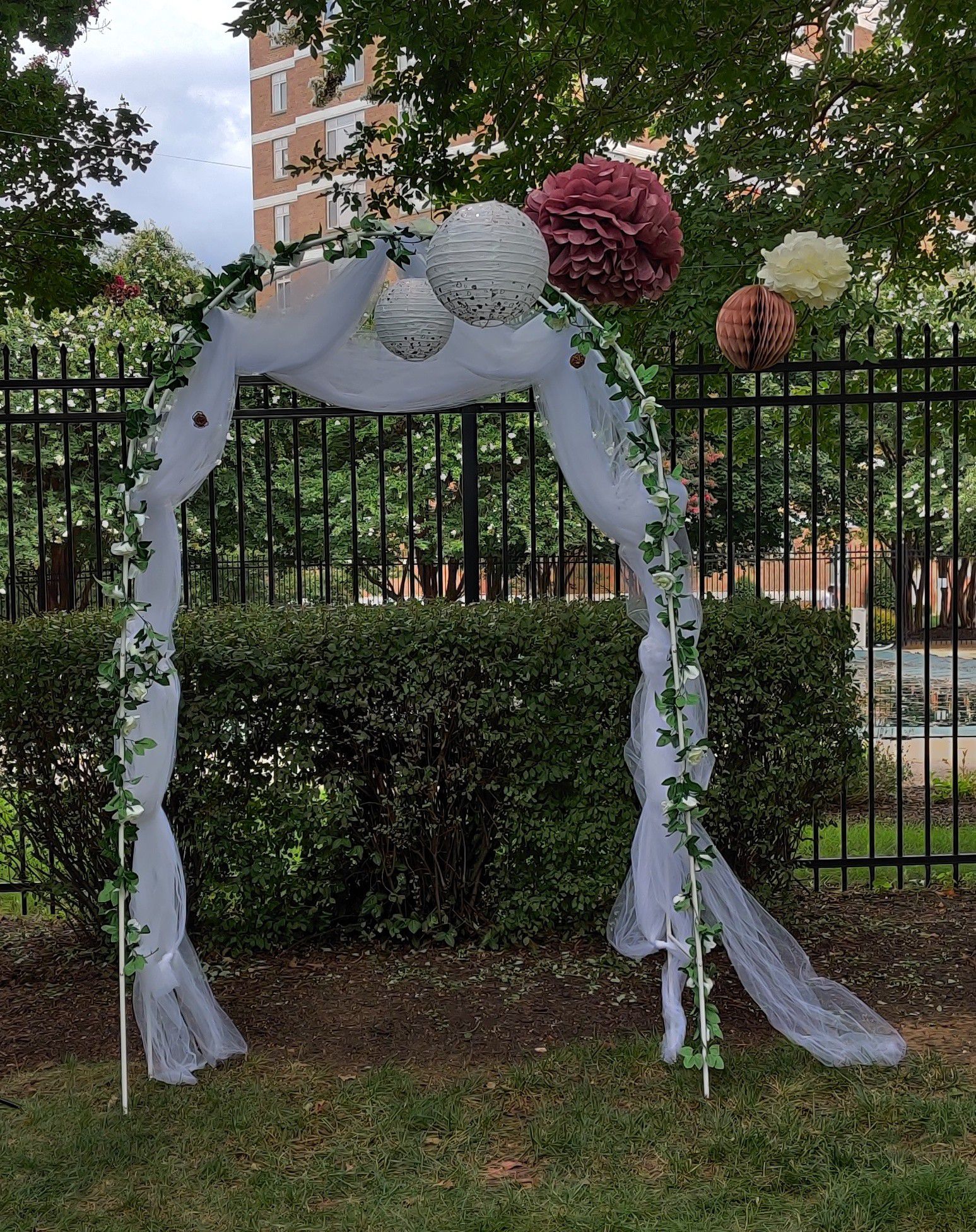 Wedding arch, white tulle and artificial rose vines