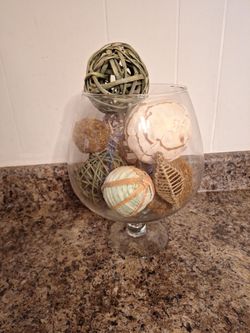 glass snifter vase filled with decorative wicker and rattan balls