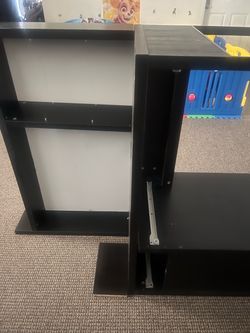 Black ikea desk with 2 drawers, whiteboard, shelf, and cabinet