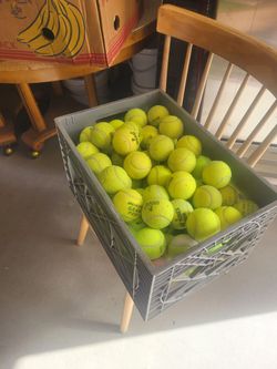 130 tennis balls in a strong plastic milk crate