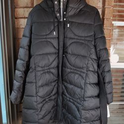 The Vince Camuto Puffer Coat is a stylish and practical mid-length winter jacket designed for women. Made of polyester with a polyester lining, this c
