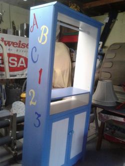 A custom painted baby cabinet to hang clhotes an for storage.