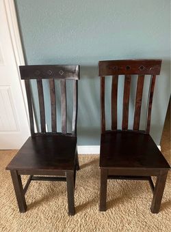 Two Cost Plus brown wood dining chairs