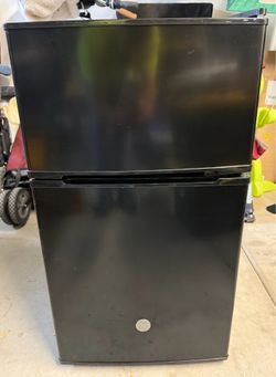 Small black GE refrigerator with freezer.
