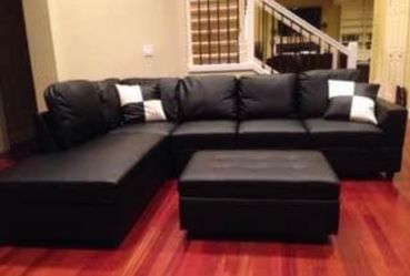 Black leather sectional couch and ottoman