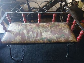 Victorian style wrought iron bench with floral design cushion