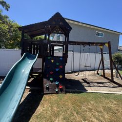 Play set rock wall and swings and slide and monkey bars