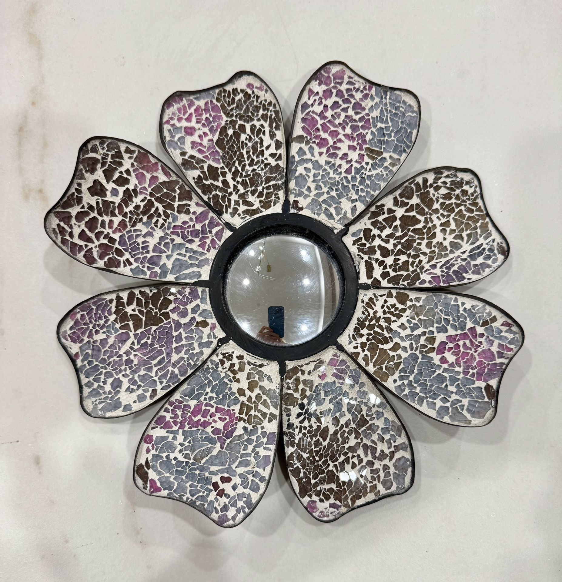 A decorative mosaic floral wall mirror.
