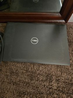Sony Playstation black and dell laptop Grey