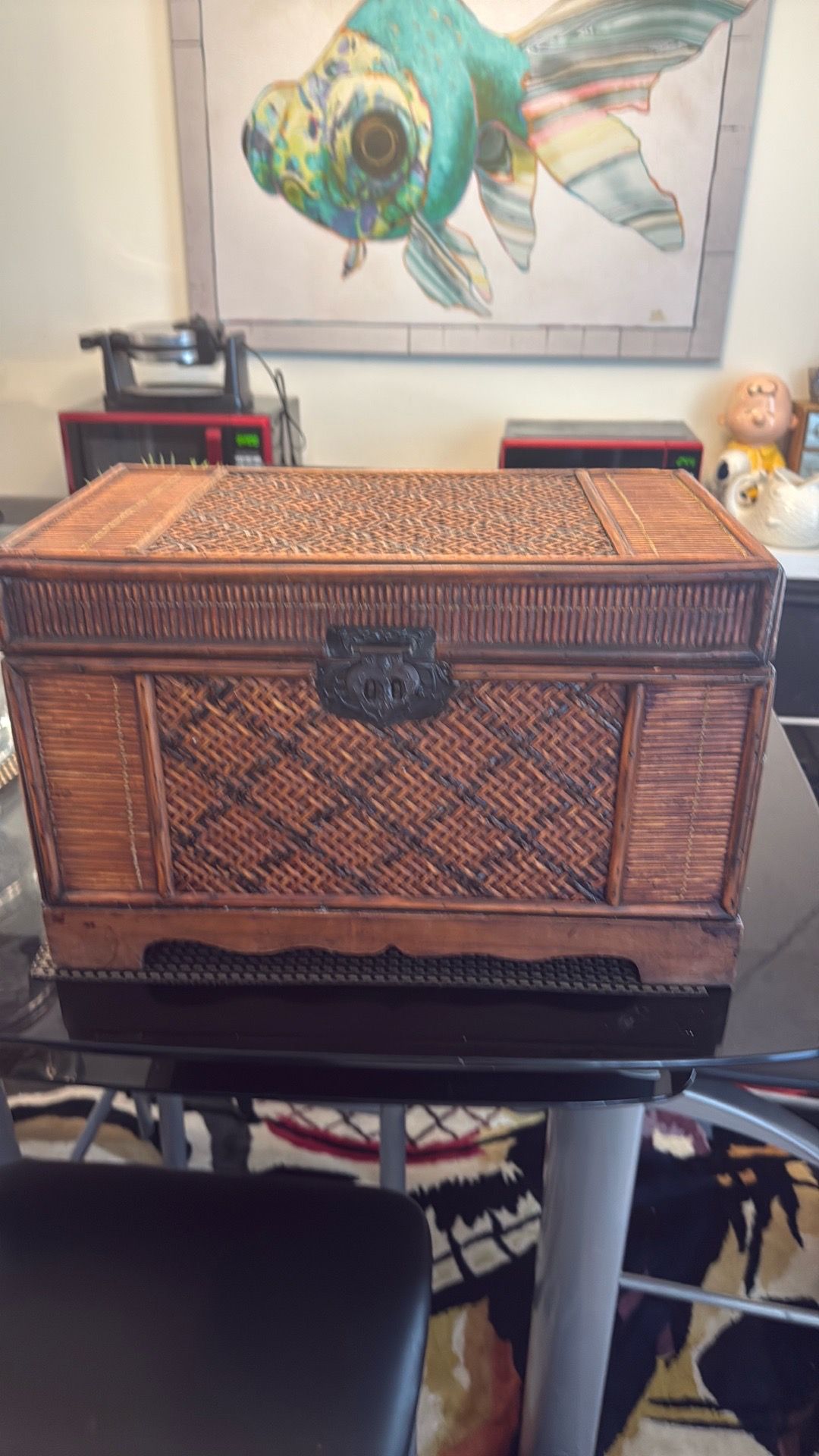 Vintage woven wicker and wood storage trunk with ornate metal latch.