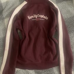 Old Navy full-zip track jacket in maroon with white stripes and the number '03' graphic on the chest. 