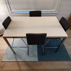 glass-top dining table with chrome legs + matching 4 IKEA Volfgang Chairs
