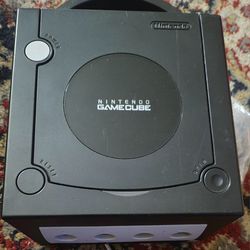 Black Nintendo game cube with two remotes