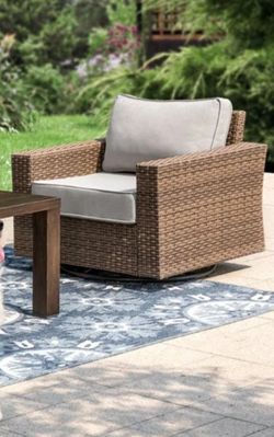 Brand new Phi Villa outdoor swivel chair with tan cushions.