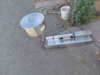 horizontal pneumatic liquid and paste piston filling machine, commonly used for dosing semi-viscous or liquid products like sauces, creams, or oils.