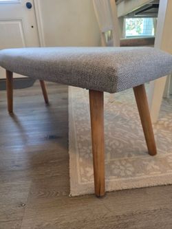 Grey fabric bench with wooden legs