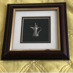 Frame with a "dallah"/Arabic Coffee pot inside it.