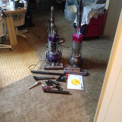 Two Dyson Ball Vacuums. One Doesn't Have A Piece That Connects To The Handle.