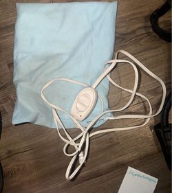 Preowned standard-size Sunbeam Electric Heating Pad, featuring a light blue washable cover and a multi-setting slide controller.Key Product DetailsDim