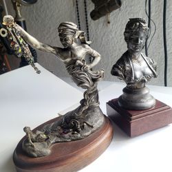 A bronze bust of a woman on a wooden base