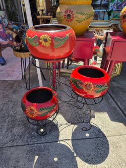 Metal stand with spherical red clay pots decorated with hand-painted flowers.