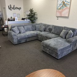 Large grey corduroy sleeper sofa with storage chaise