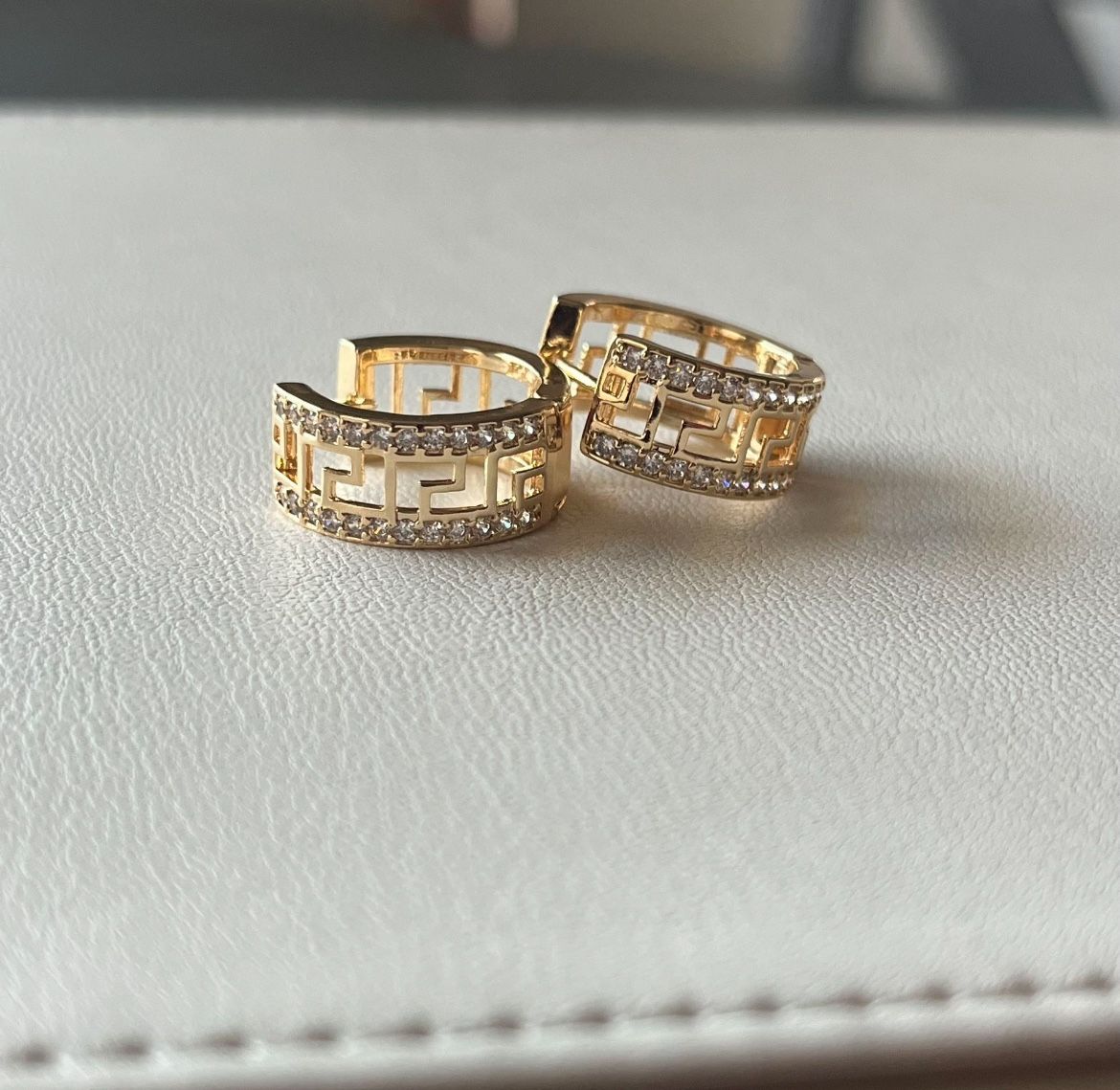 Versace style gold-plated hoop earrings with a Greek Key pattern and clear rhinestones