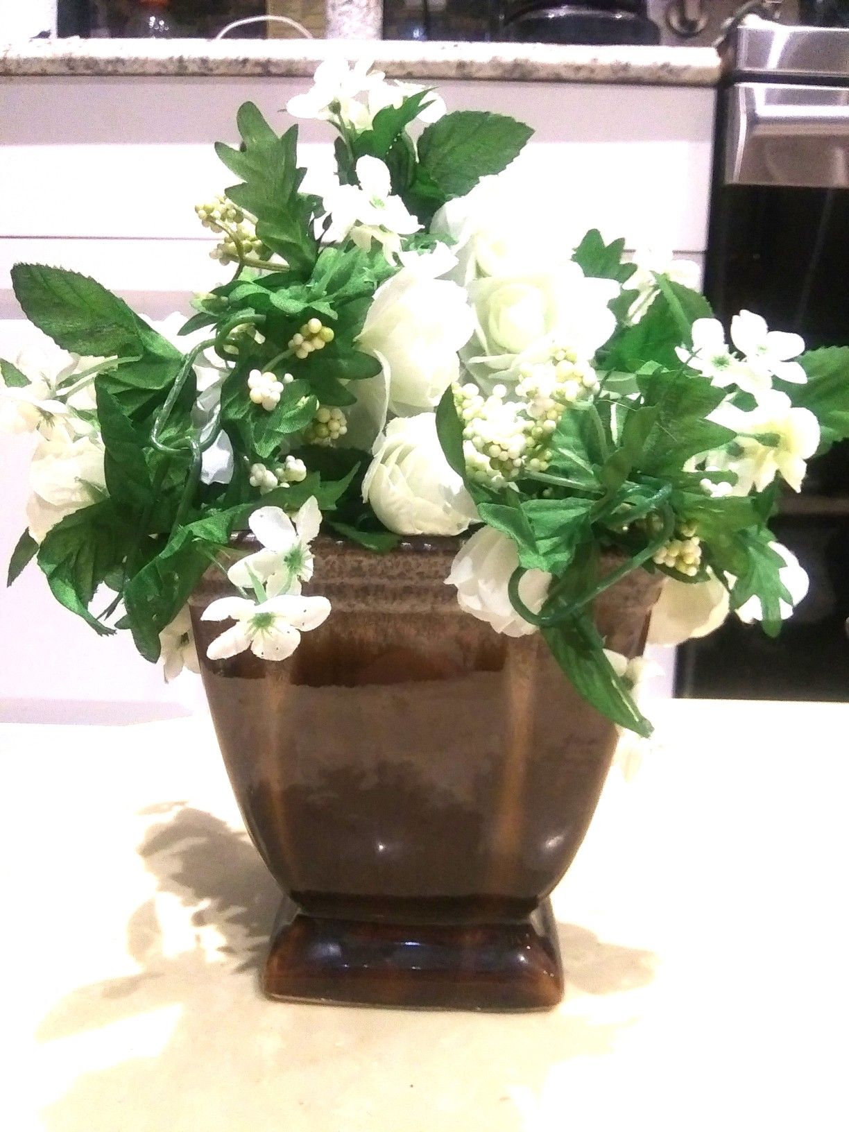 brown vase with artificial flowers