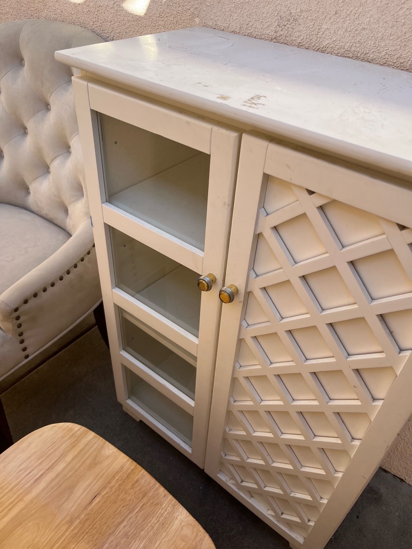 White storage/accent cabinet with glass door shelving and decorative lattice door.