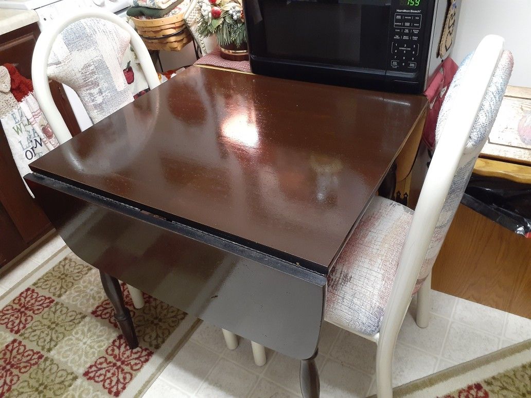 Brown table that folds with 2 multi colored chairs